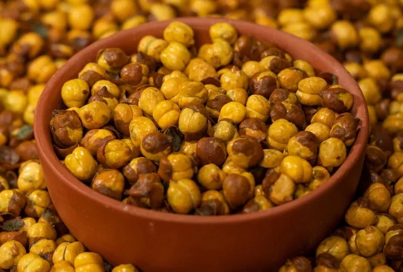 Roasted Gram, or Bengal Gram or Chana Dal, is a popular ingredient in Indian cuisine. It is a legume that high in protein, fiber, and other nutrients. Roasted Gram is a considered versatile ingredient in various type of dishes, including salads, soups, stews, and curries. Roasted Gram is also considered a great snack option because it is crunchy, tasty, and filling. This article will discuss the 10 benefits of eating Roasted Gram and how wellhealthorganic.com can help you incorporate this superfood into your diet. A rich source of protein: Roasted Gram is an excellent source of protein that thing making it an ideal food for vegetarians and vegans. Protein is essential element for building and repairing tissues, muscles, and bones. It also prove helpful to regulate hormones, enzymes, and other chemicals in the body. Roasted Gram contains about 22 grams of protein per 100 grams, higher than most other legumes. Full of plant protein: Plant protein is an excellent alternative to animal protein as it is more sustainable, ethical, and healthier. Roasted Gram is a great source of plant protein that is easy to digest and absorb. Plant protein also contains less fat, cholesterol, and calories than animal protein. Incorporating Roasted Gram into your diet can help you meet your daily protein needs without consuming too much meat. Helps manage weight / May help with weight loss: Roasted Gram is a low-calorie, high-fiber food that can help you manage weight. Fiber is essential for promoting feelings of fullness, reducing appetite, and preventing overeating. Roasted Gram contains about 17 grams of fiber per 100 grams, higher than most other legumes. Eating Roasted Grams can help you feel full for longer and reduce your overall calorie intake, leading to weight loss. Manage blood sugar levels: Roasted Gram has a low glycemic index, which means it does not cause a rapid increase in blood sugar levels. It makes it an ideal food for those with diabetes or those at risk of developing diabetes.. Roasted Gram also contains complex carbohydrates that are digested slowly, providing a steady source of energy and preventing blood sugar spikes. Protects against cardiovascular diseases: Roasted Gram is rich in antioxidants, vitamins, and minerals that benefit heart health. Antioxidants are reliable for preventing cell oxidative damage which leading to inflammation, heart disease, and other chronic diseases. Roasted Gram also rich in various ingredients such as potassium, magnesium, and folate, which help to lower blood pressure, reduce cholesterol levels, and improve blood flow. Aids in digestion: Roasted Gram is a great source of dietary fiber that helps to promote healthy digestion. Fiber helps to bulk up stools, soften them, and make them easier to pass. It can help to prevent various digestive issues, including constipation and hemorrhoids. Roasted Gram also contains digestive enzymes that help to break down food and promote nutrient absorption. Protects against cancer: Roasted Gram contains phytochemicals that have anti-cancer properties. These phytochemicals is mainly utilized to prevent the growth and spread of cancer cells, reducing the risk of developing cancer. Roasted Gram also contains saponins, which have been shown to inhibit the growth of tumors in the colon and other parts of the body. Prevention of Iron Deficiency: Roasted Gram is a good source of iron, which is essential for producing hemoglobin in the blood. Hemoglobin is the main protein that use to carries oxygen to the cells in the body. Iron deficiency can lead to anemia, fatigue, weakness, and other health issues. Eating Roasted Gram can help to prevent iron deficiency and promote healthy blood cells.