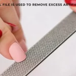 What grit of nail file is used to remove excess artificial nail product